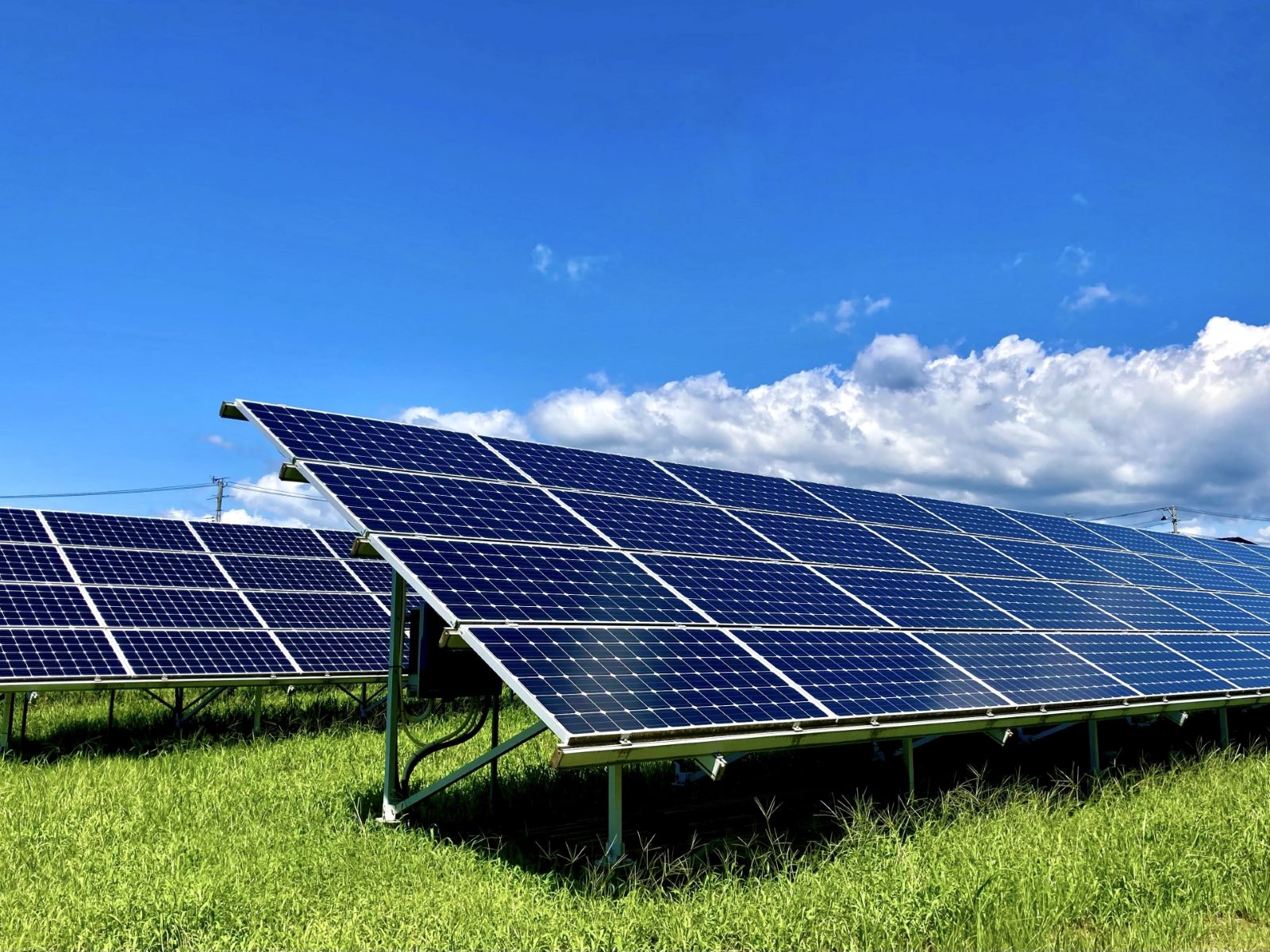 朝の光に照らされた太陽光パネルと蓄電池設備